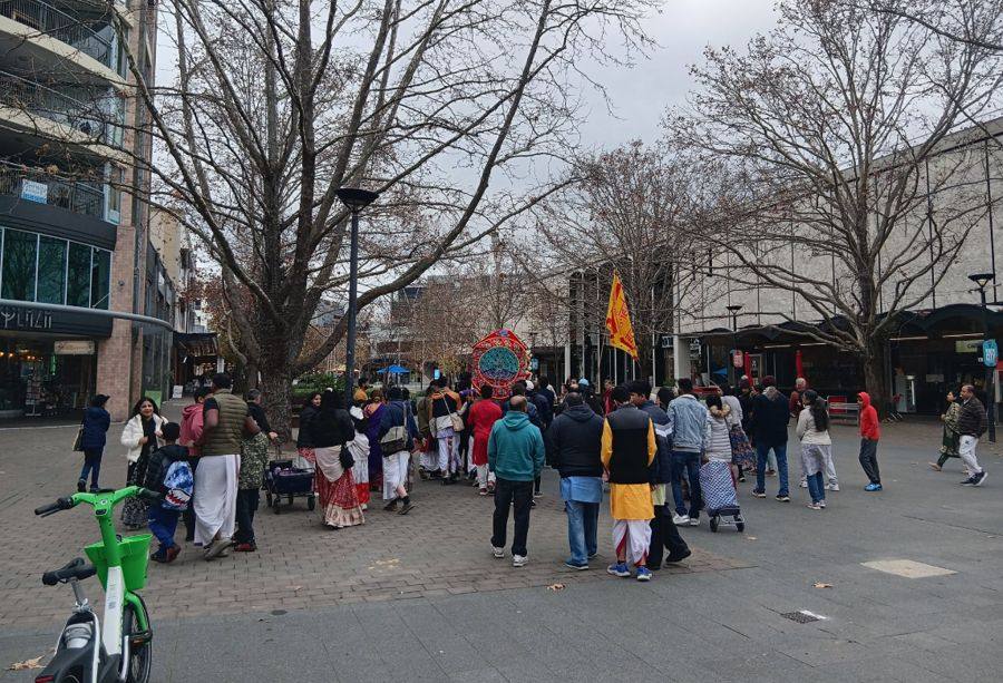 A procession moving through the city centre in Canberra, bare winter trees overhead.
